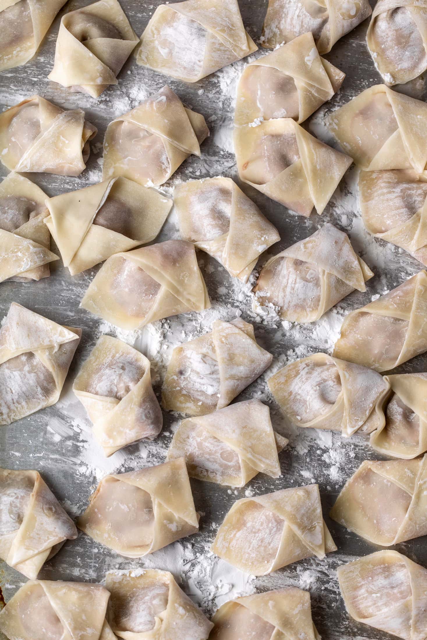 folded ground lamb dumplings on prepared baking tray.