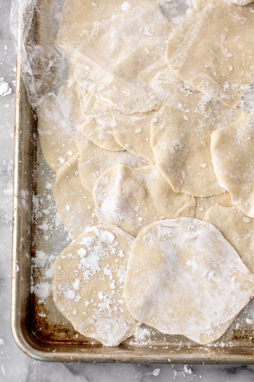 sheet pan filled with stacked dumpling wrappers.
