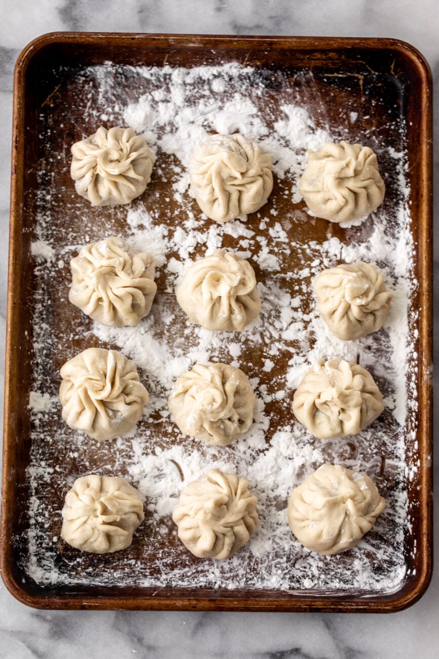 baking sheet filled with wrapped dumplings ready to cook or to freeze.