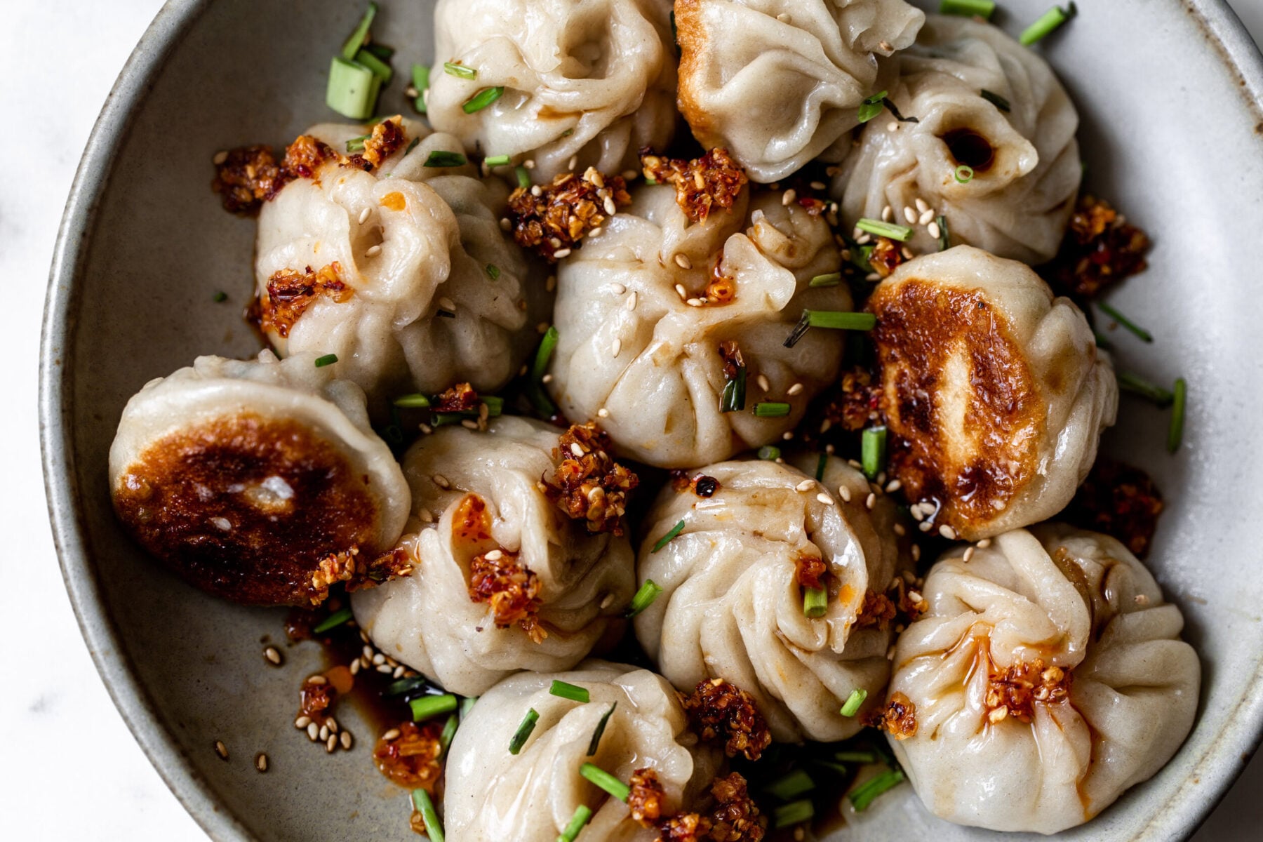 homemade chinese-inspired pork and chive filled top twisted dumpling pan-fried.