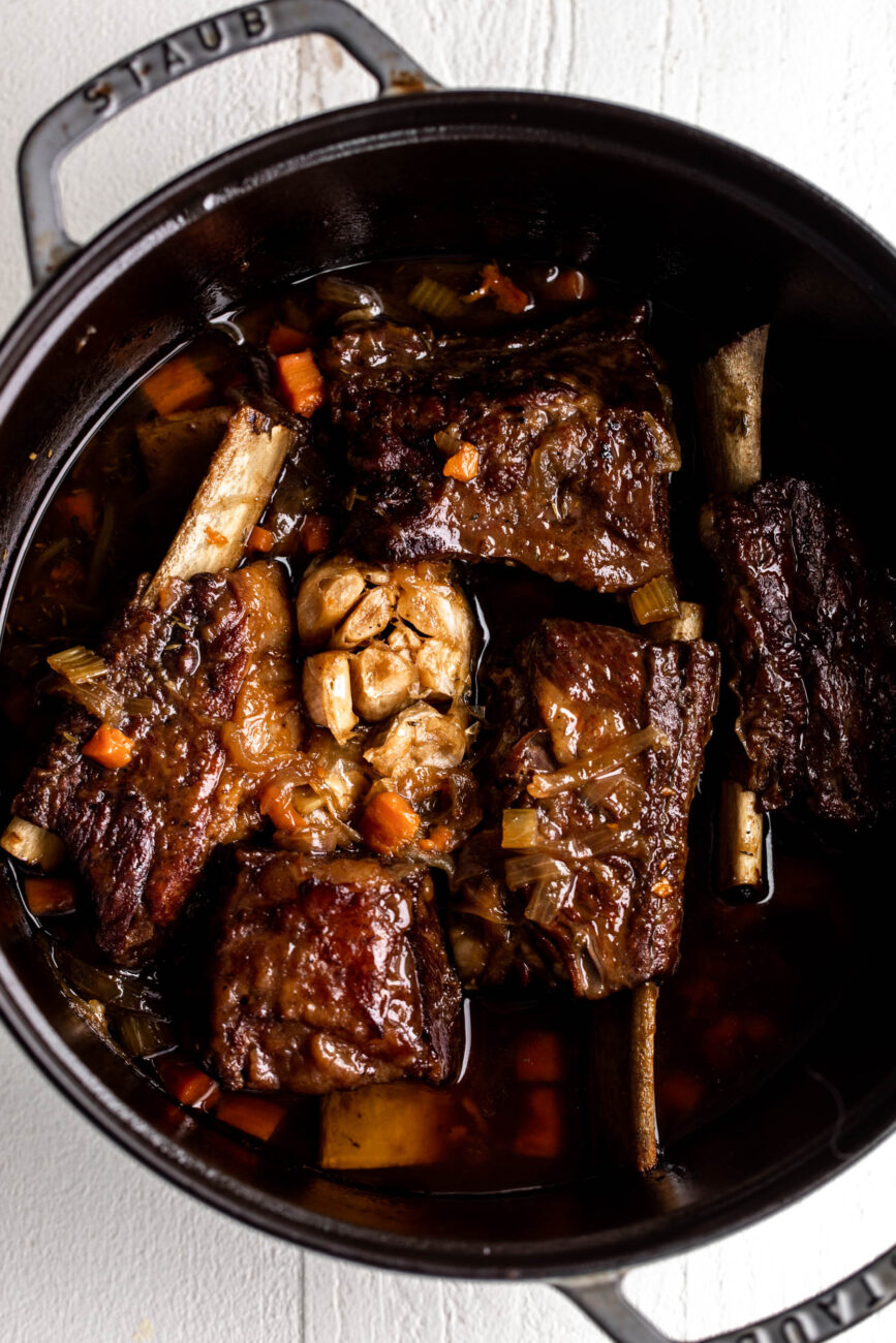 maple bourbon braised short ribs in dutch oven with braising liquid.