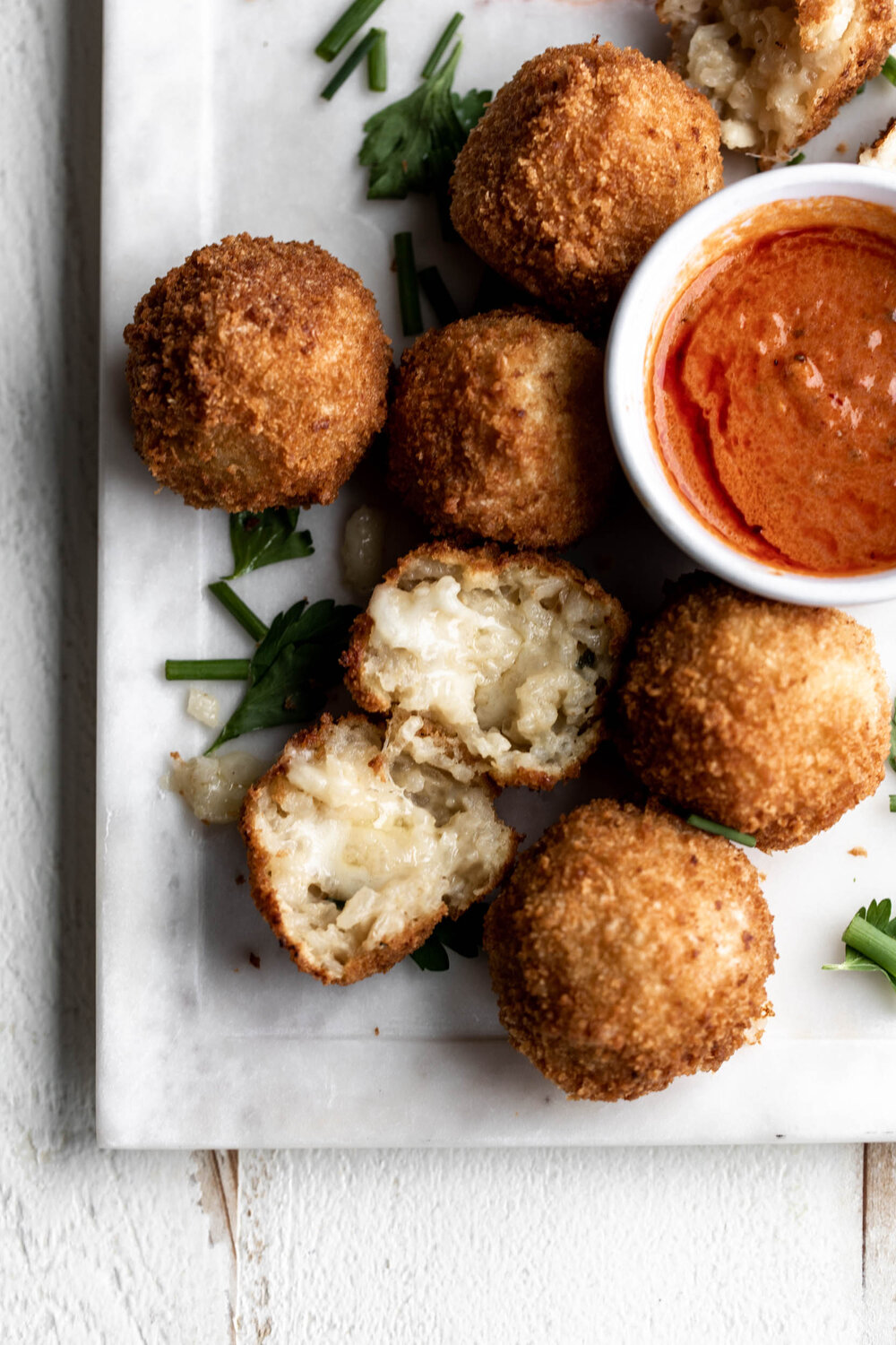 Crispy fried risotto balls stuffed with cheese and paired with spicy creamy marinara