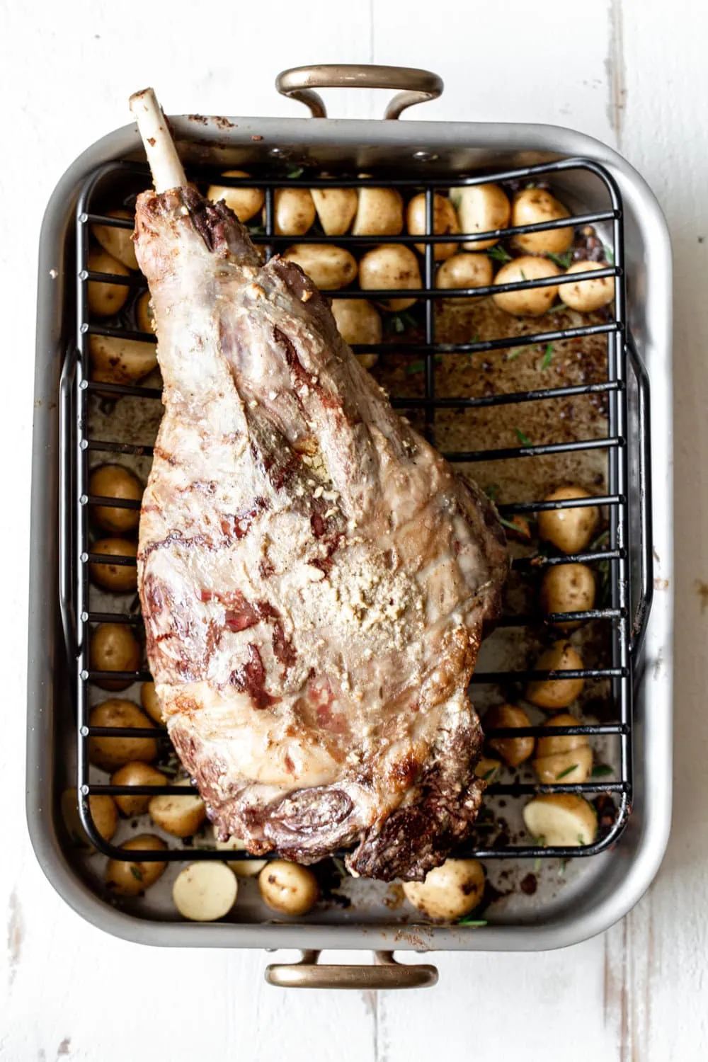 whole leg of lamb with potatoes ready for oven