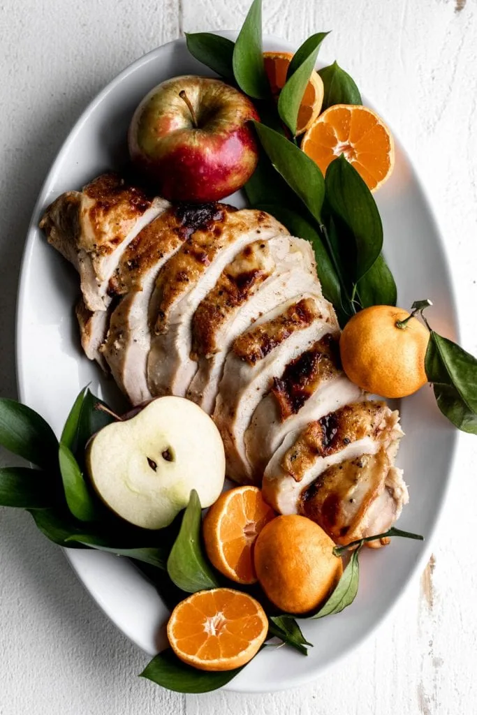 sliced Brined Turkey Breast for Two garnished with apples and citrus.