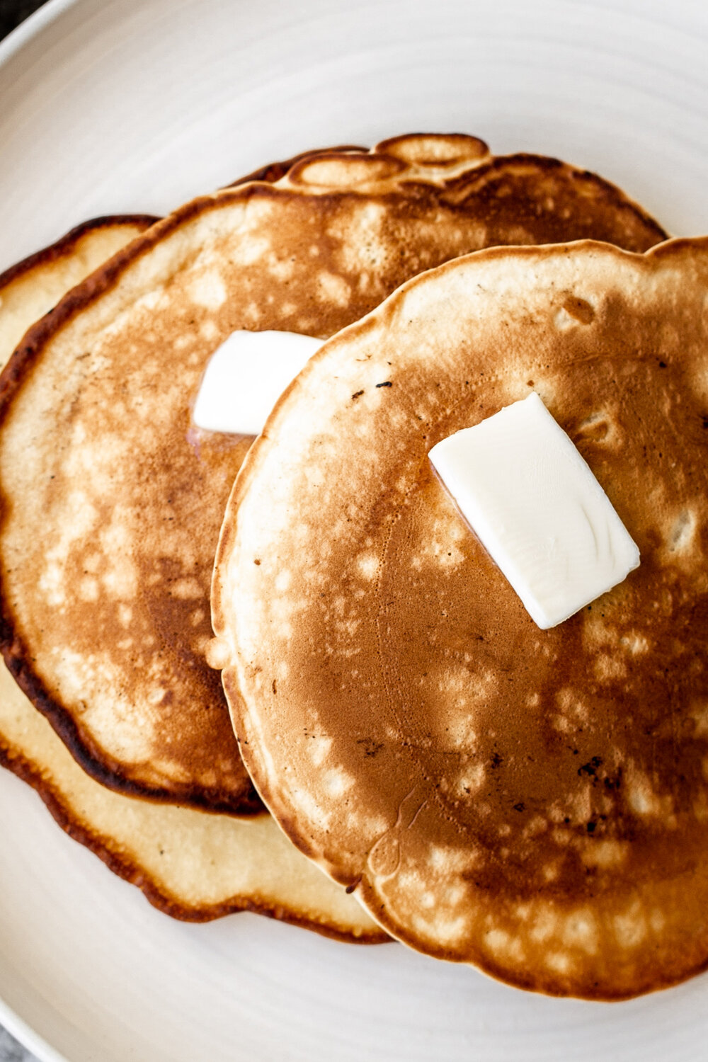 Apple Pancakes golden brown topped with pats of butter