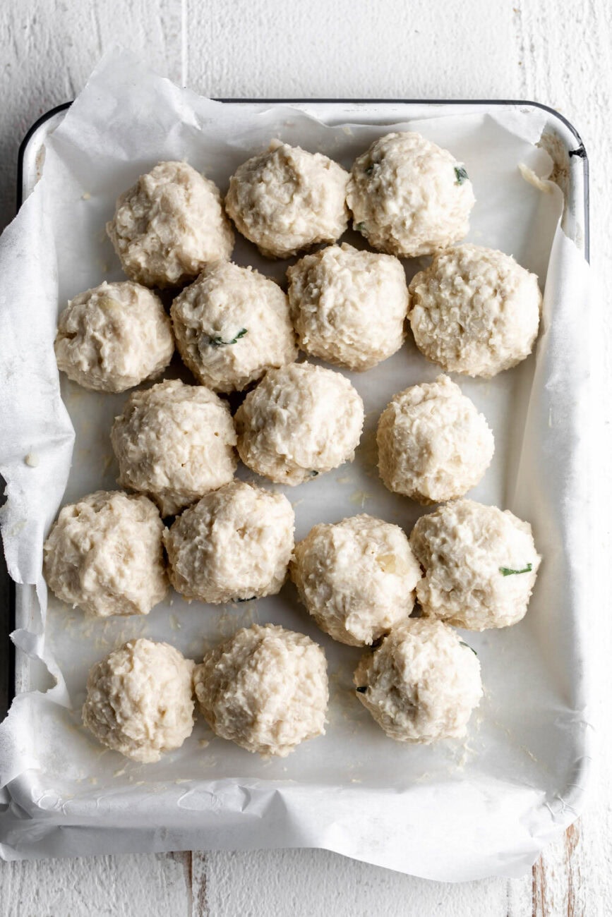 rolled arancini on baking sheet.