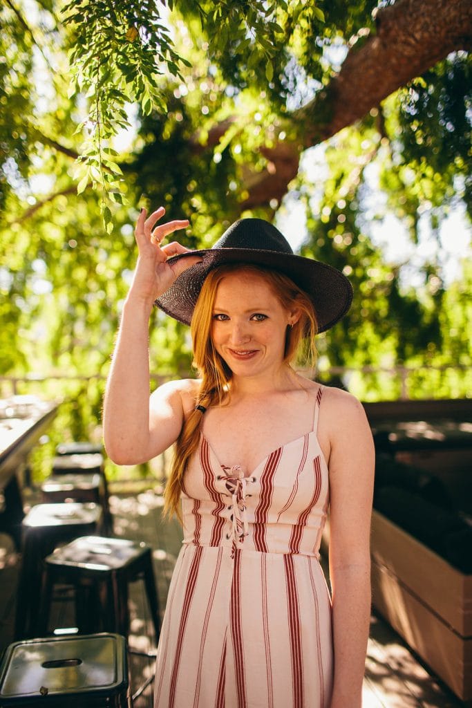 woman holding her hat.