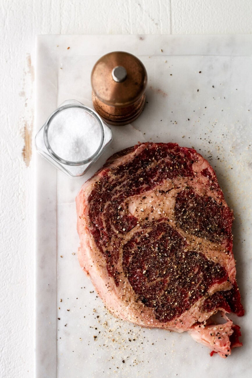 ribeye steak seasoned with salt and pepper.