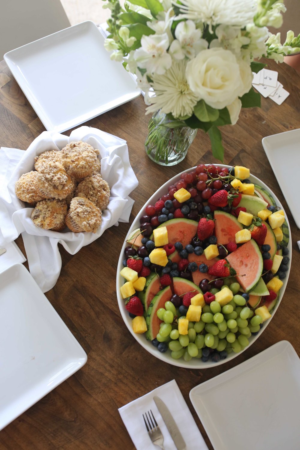 coffee cake muffins and fruit platter with flower arrangement