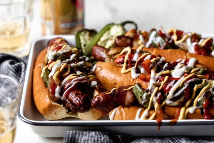 bacon wrapped hot dogs with jalapeños. peppers and onions danger dogs.