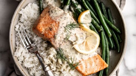 baked lemon dill salmon with green beans and steamed rice in a stone bowl.