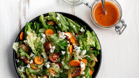 fried buffalo chicken salad with chopped green leaf lettuce with side of buffalo sauce.