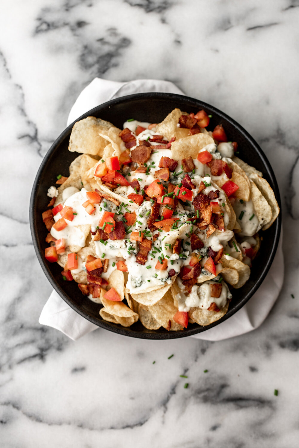 homemade potato chips with blue cheese fondue, bacon and tomatoes 
