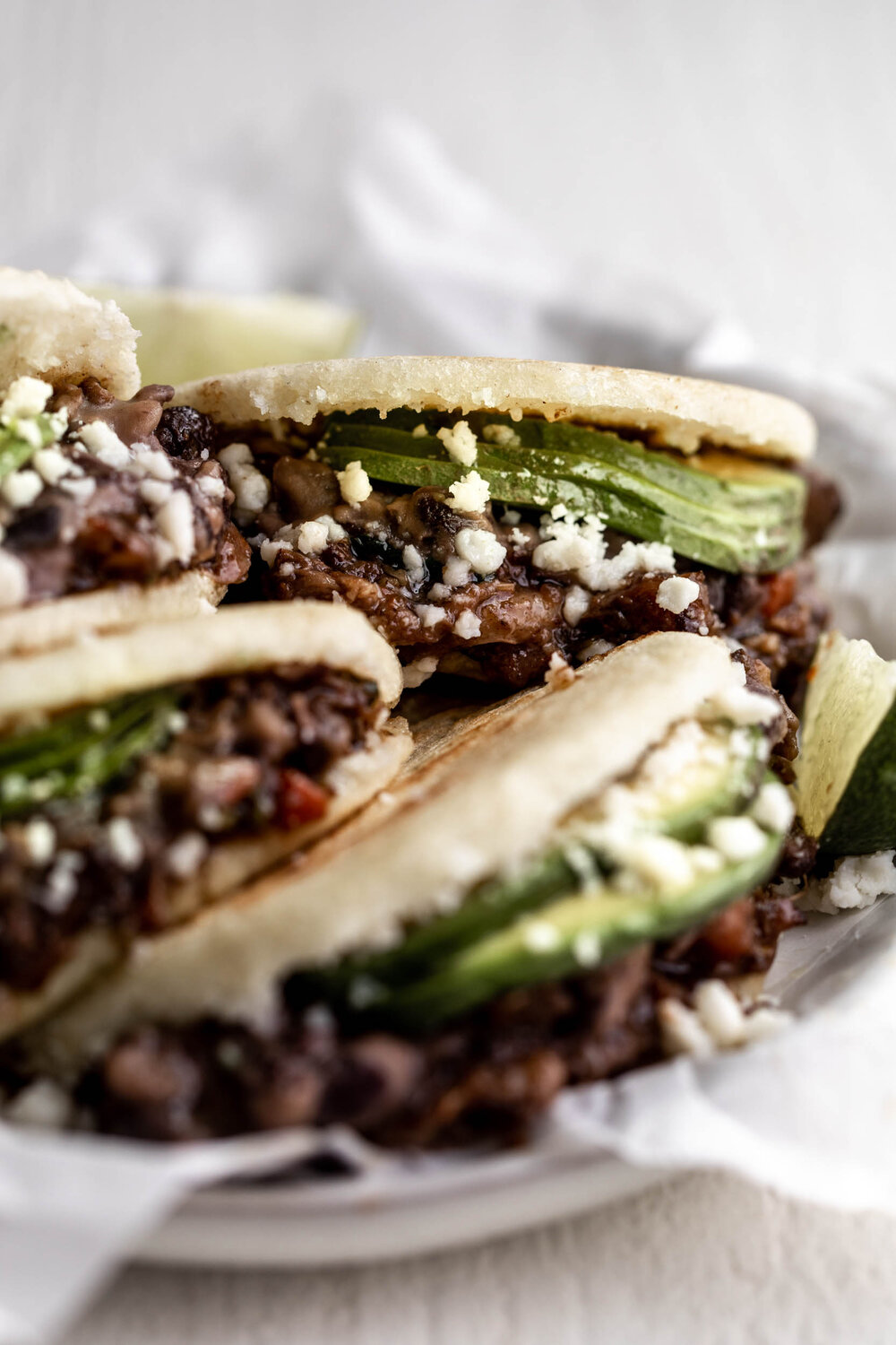 Braised Oxtail Arepas with avocado black beans and cotija cheese