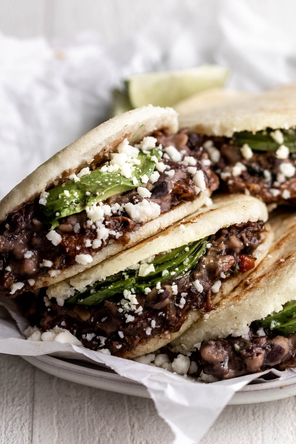 Braised Oxtail Arepas with avocado and black beans in parchment paper