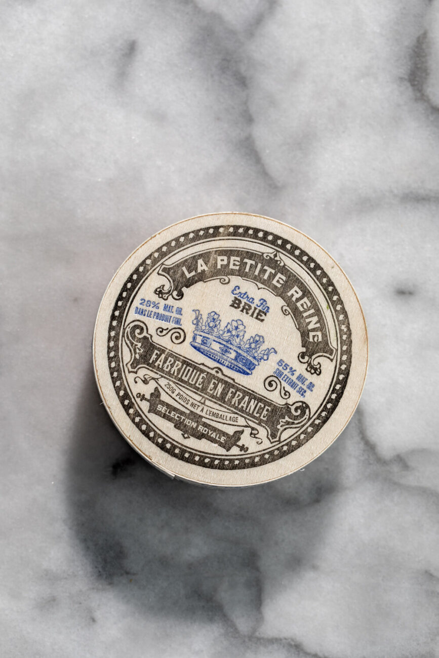 wheel of brie cheese in wood box.