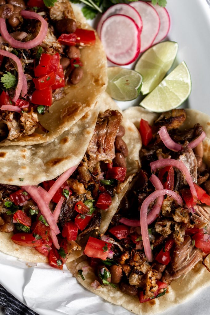 carnitas taco overhead photo topped with pickled onion and pico de gallo 
