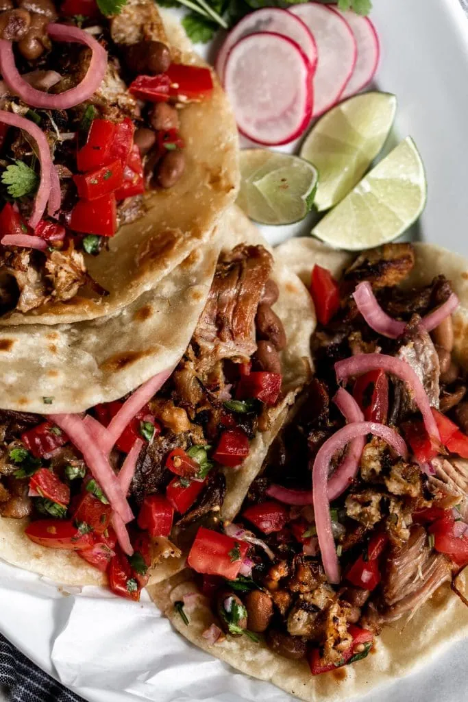 carnitas taco overhead photo topped with pickled onion and pico de gallo 