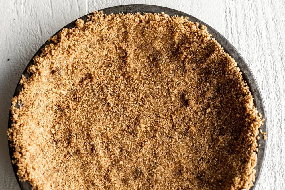 Graham cracker crust pressed into pie baking dish for Cranberry Ginger Pie