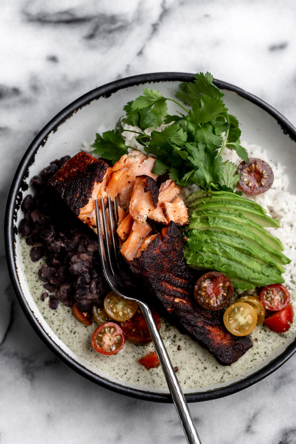 Crispy Blackened Salmon with Cilantro Cream Sauce over rice with avocado and tomatoes