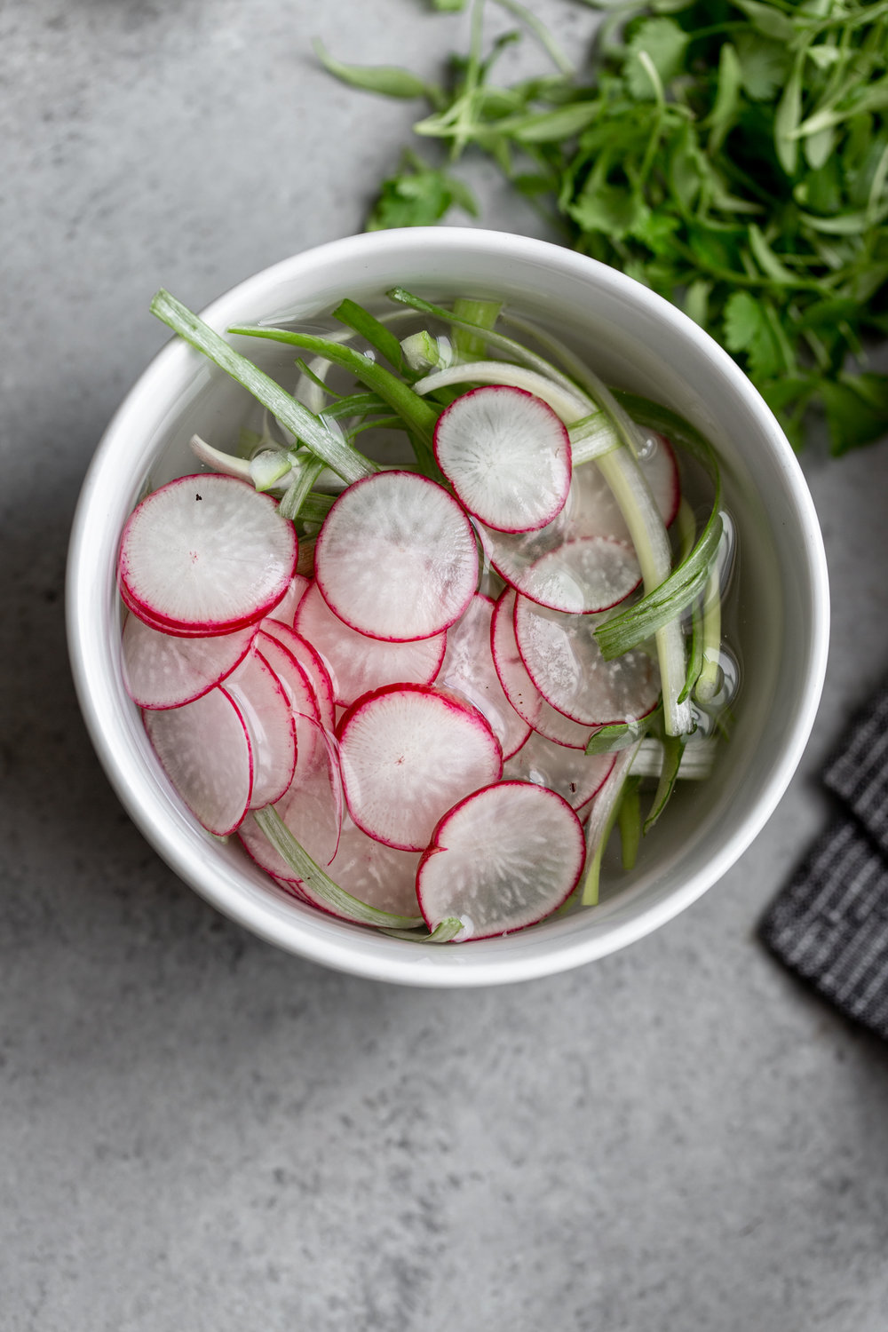 thinly sliced radish and green onion in water