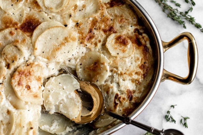 creamy dauphinoise potatoes with serving spoon.