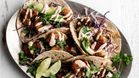 Grilled Honey Lime Shrimp Tacos with spicy crema on silver platter.