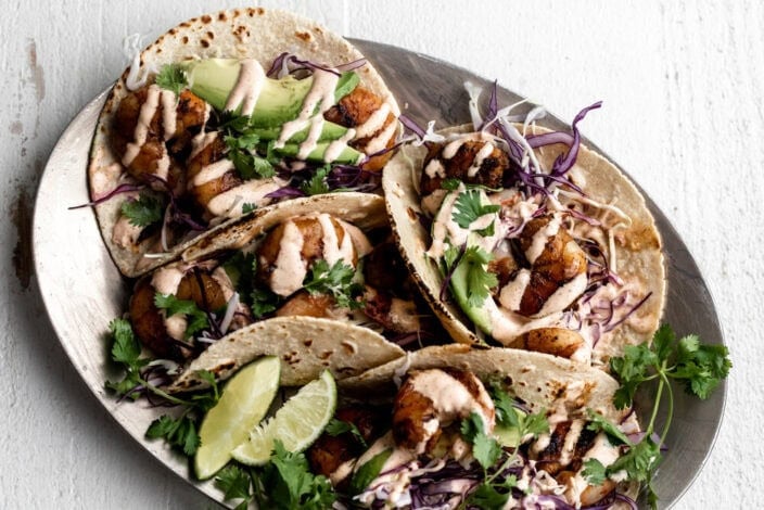 Grilled Honey Lime Shrimp Tacos with spicy crema on silver platter.