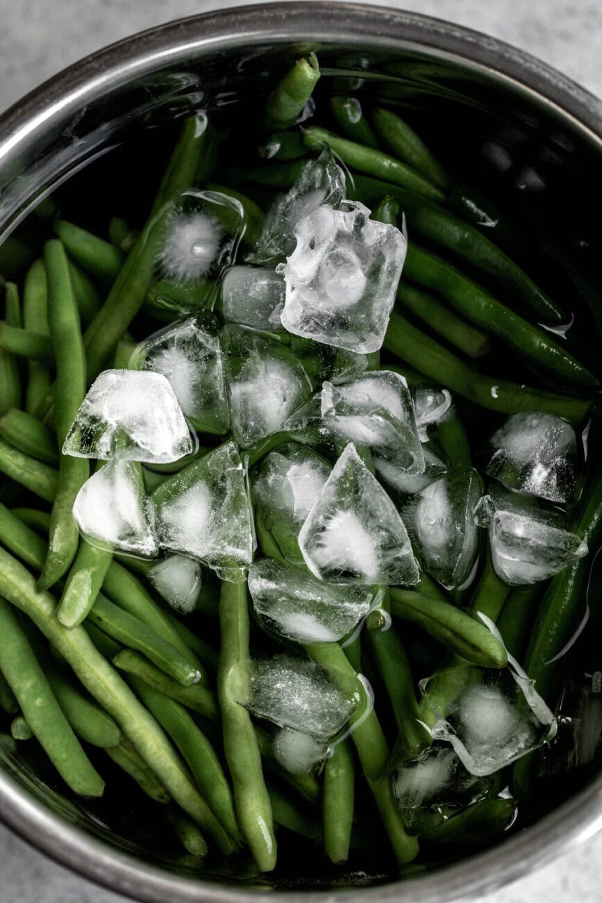 blanched green beans in ice water bath.