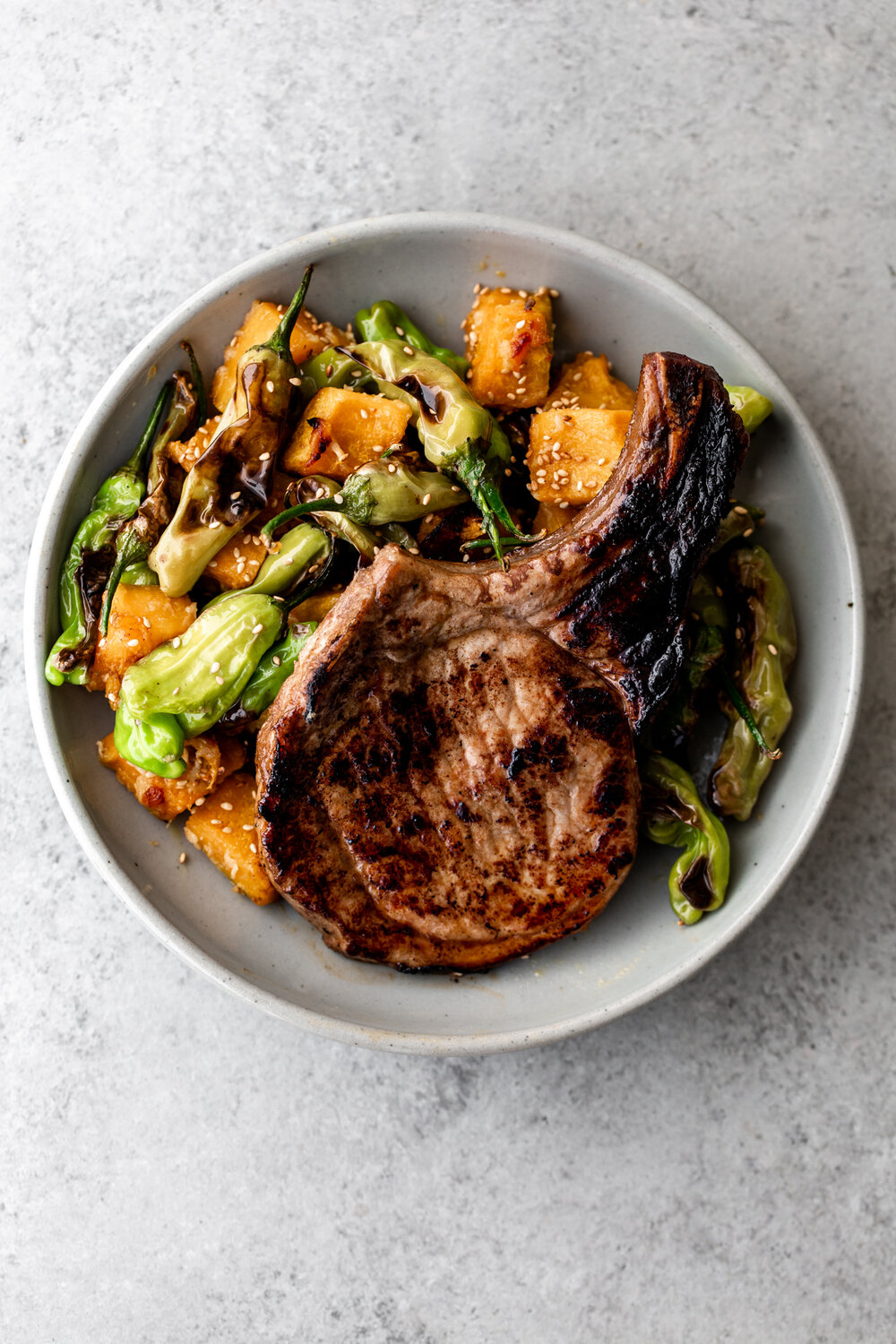 Pork chops marinated in honey-soy pan-seared served with miso roasted kabocha squash and  shishito peppers 