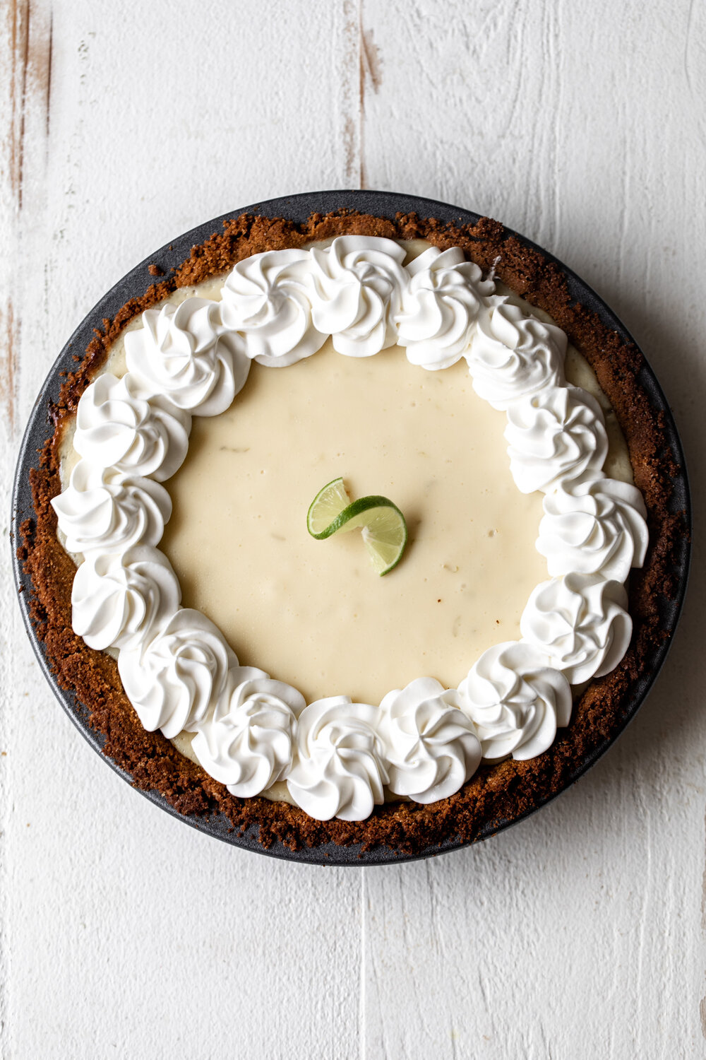 This seasonal summer key lime pie recipe is made with key lime juice and condensed milk topped with sour cream whipped cream for a tasty dessert.