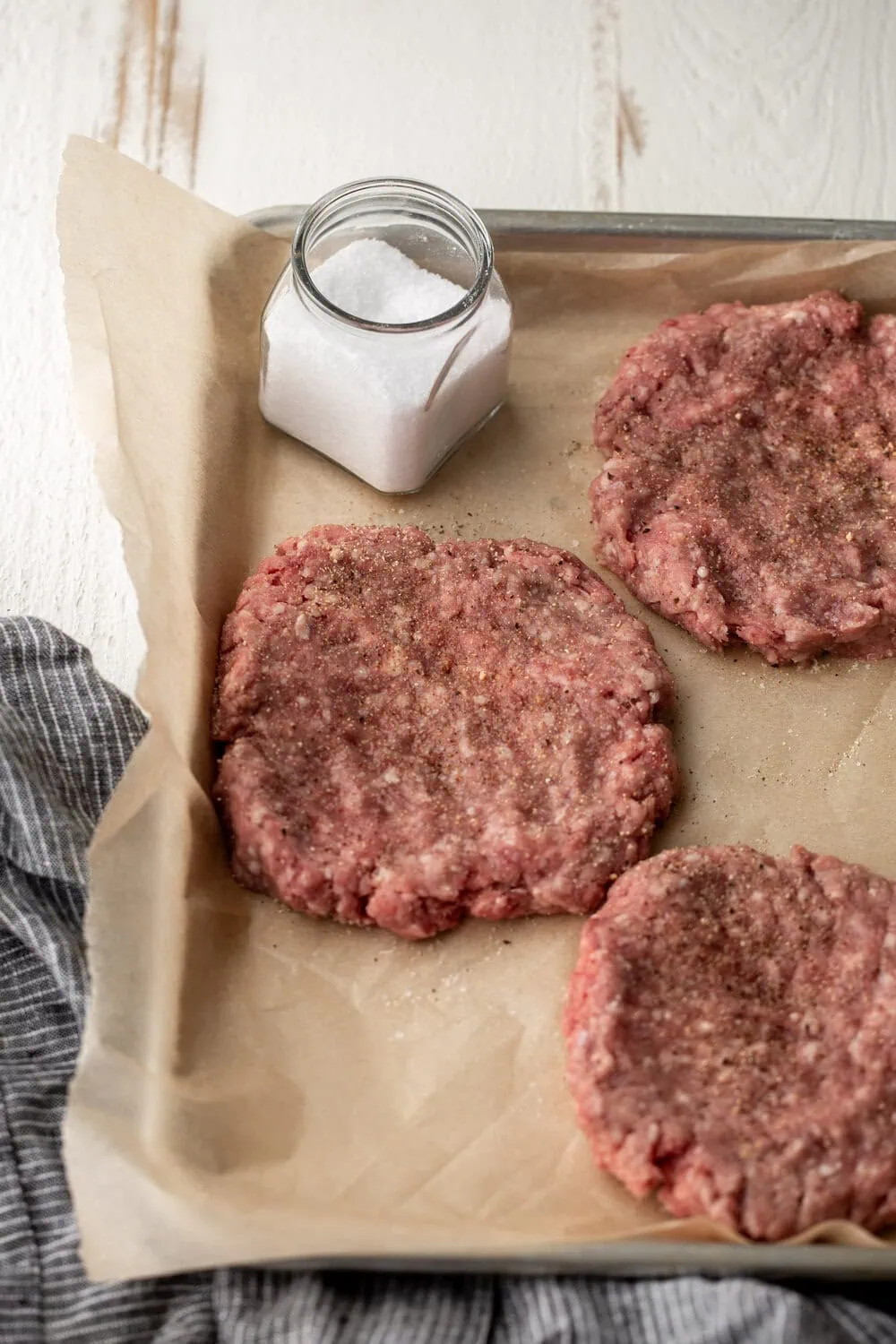 shaped meat patties on baking sheet