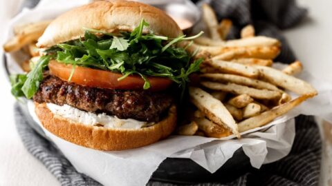 lamb burger with tomato arugula and aioli on a bun with fries