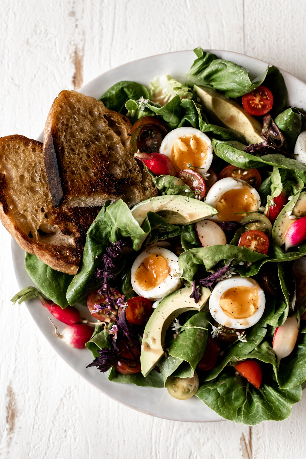 This late summer salad recipe is made with romaine lettuce, cherry tomatoes, avocado, creamy balsamic dressing and jammy soft-boiled eggs.