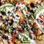 Loaded Three-Cheese Chicken Nachos with nacho cheese melted cheddar cotija cheese.