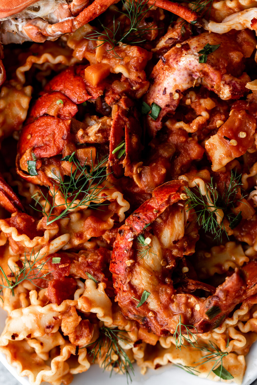 In this lobster fra diavolo recipe pasta is tossed in a tomato-based spicy arrabbiata sauce with whole lobsters.