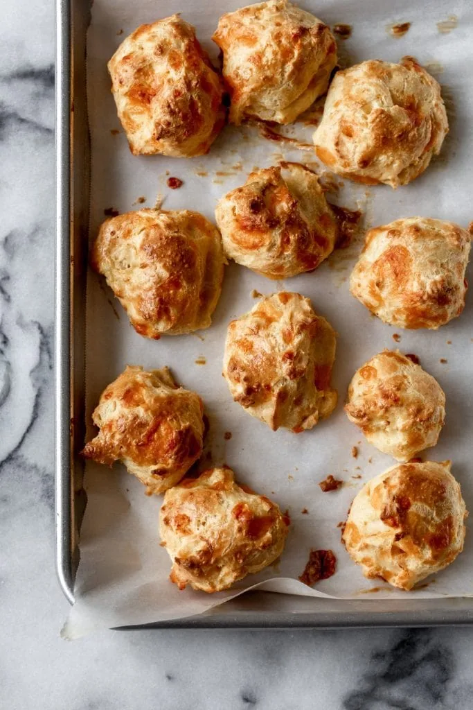 baked lobster and cheddar gougeres on parchment paper lined baking sheet