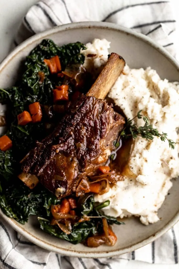 Maple Bourbon Braised Short Ribs with Caramelized Shallot and Black Pepper Mashed Potatoes over kale.