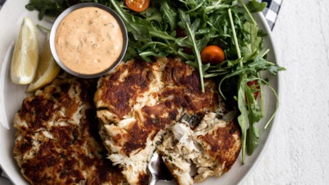 Maryland Style Crab Cakes recipe paired with remoulade sauce and arugula salad.