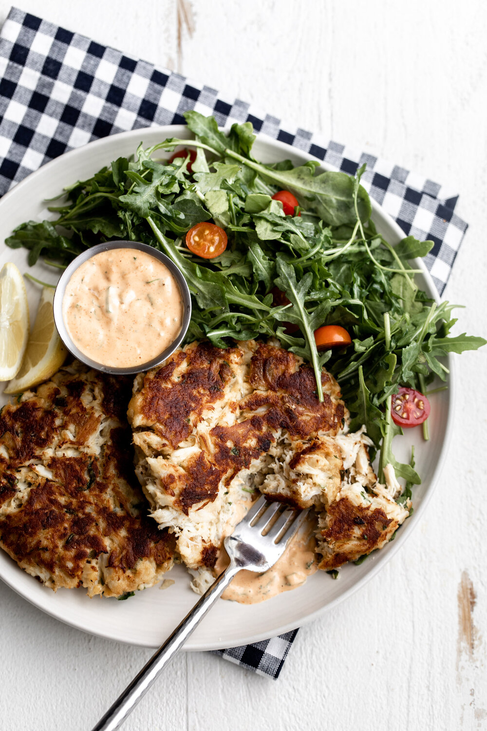 Maryland Style Crab Cakes on plate with small side salad and remoulade 