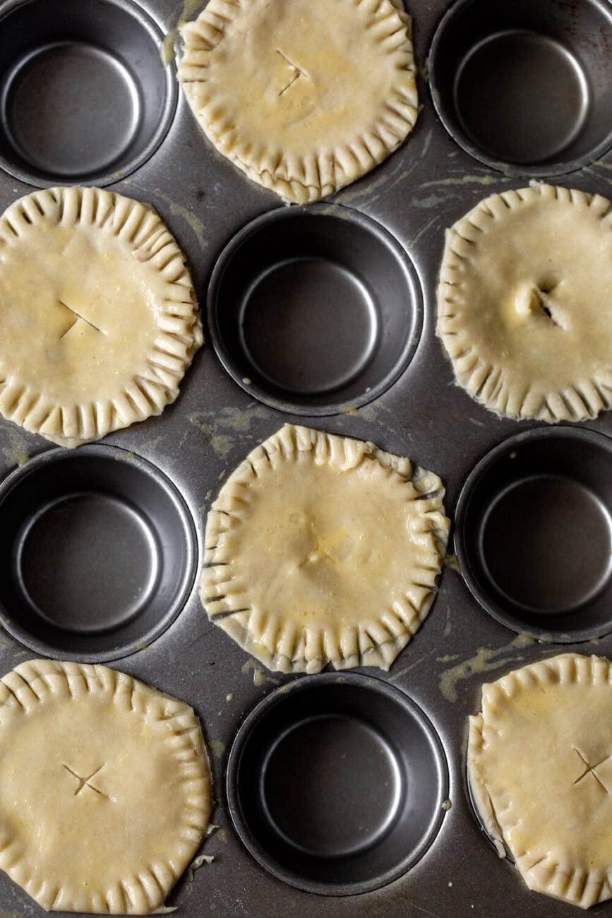 Mini Chardonnay Chicken and Prosciutto Pot Pies filled and crimped  in muffin tin.