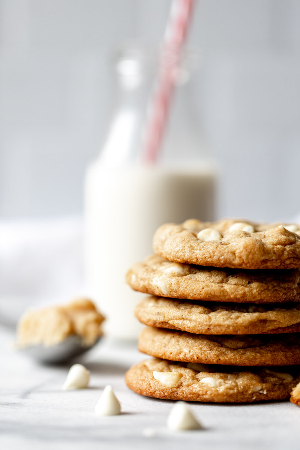 Miso Brown Butter Cookies with White Chocolate Chips stacked with milk in background