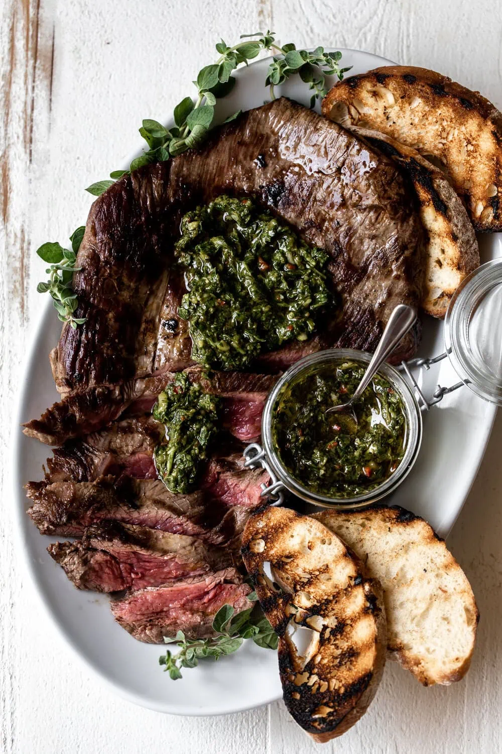 sliced Pan-Seared Flank Steak with Chimichurri Sauce and grilled bread