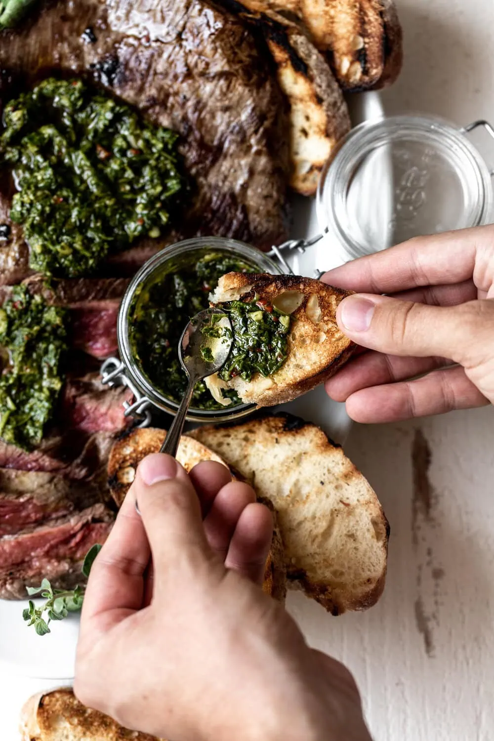 Pan-Seared Flank Steak with Chimichurri Sauce spread on grilled bread
