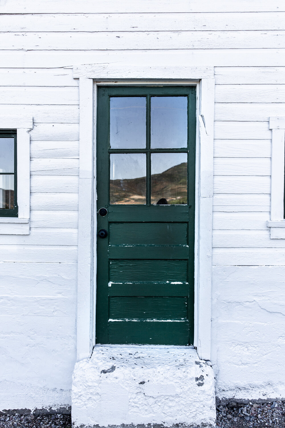 green door on white wood barn