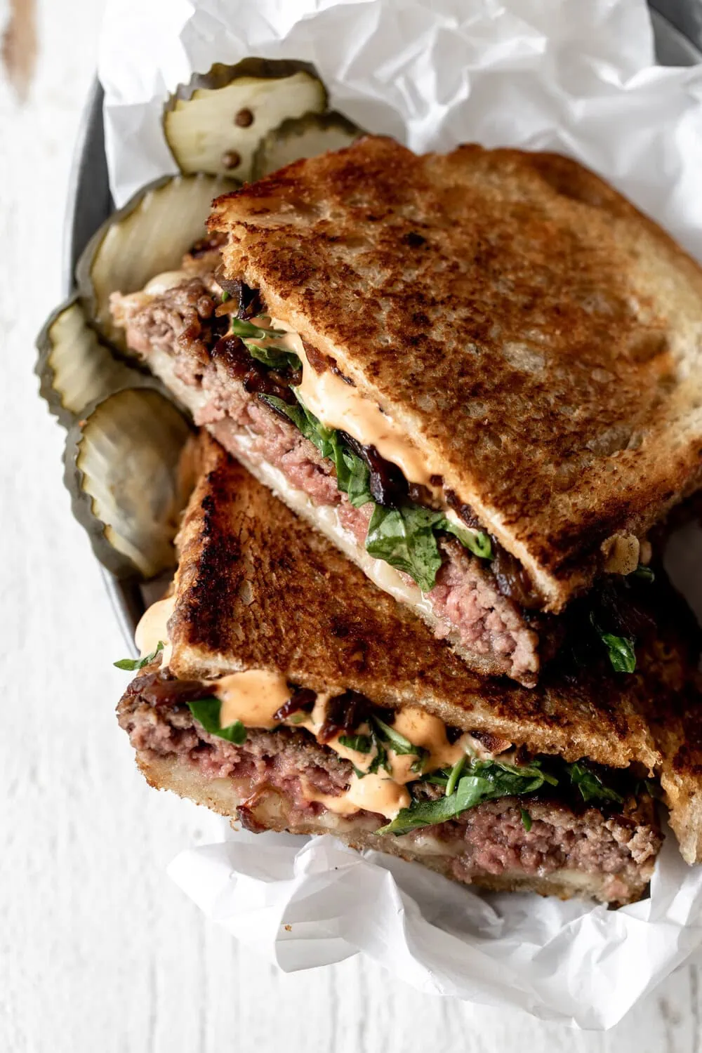 Pressed Patty Melt with Sriracha Mayo arugula and side of pickles