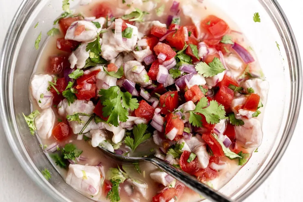white fish ceviche with tomato cilantro and red onion