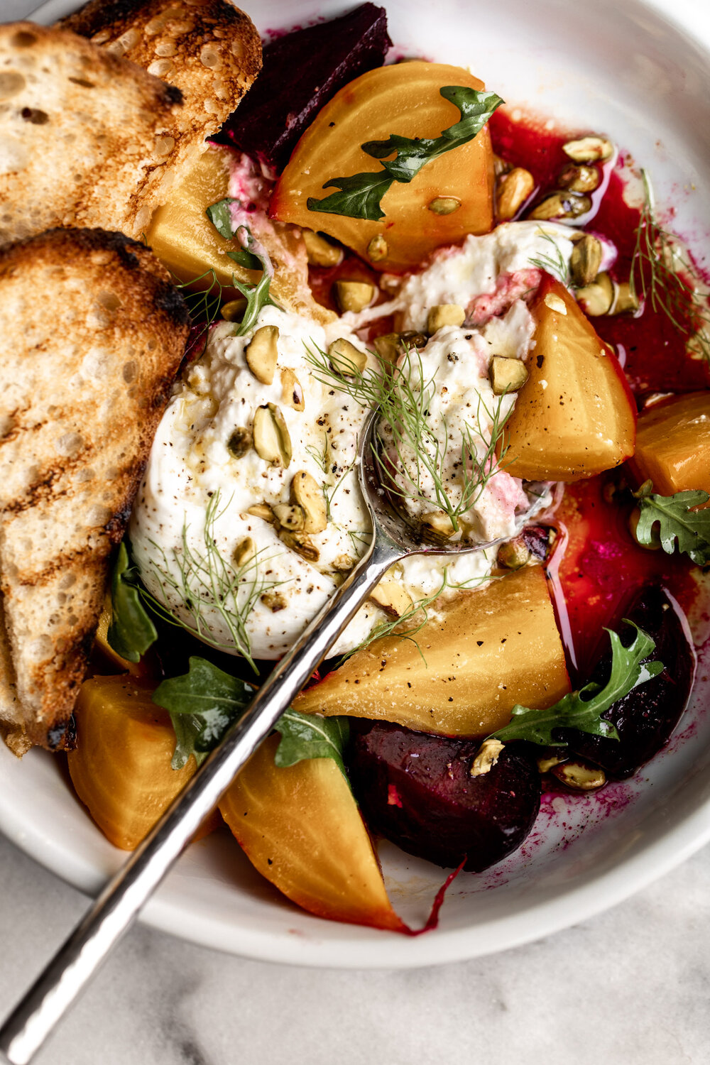 Roasted Beet Salad with Burrata topped with pistachio and fennel fronds