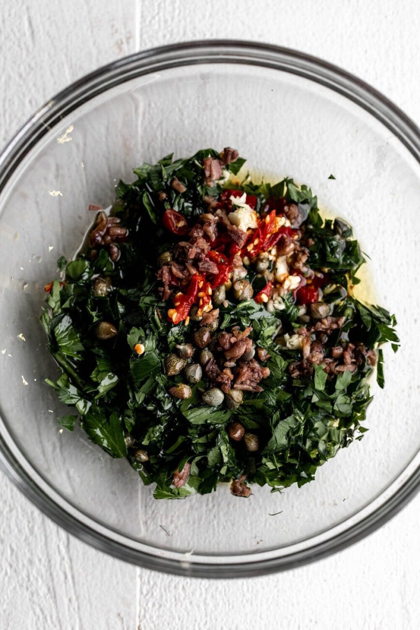 Italian salsa verde ingredients in mixing bowl.