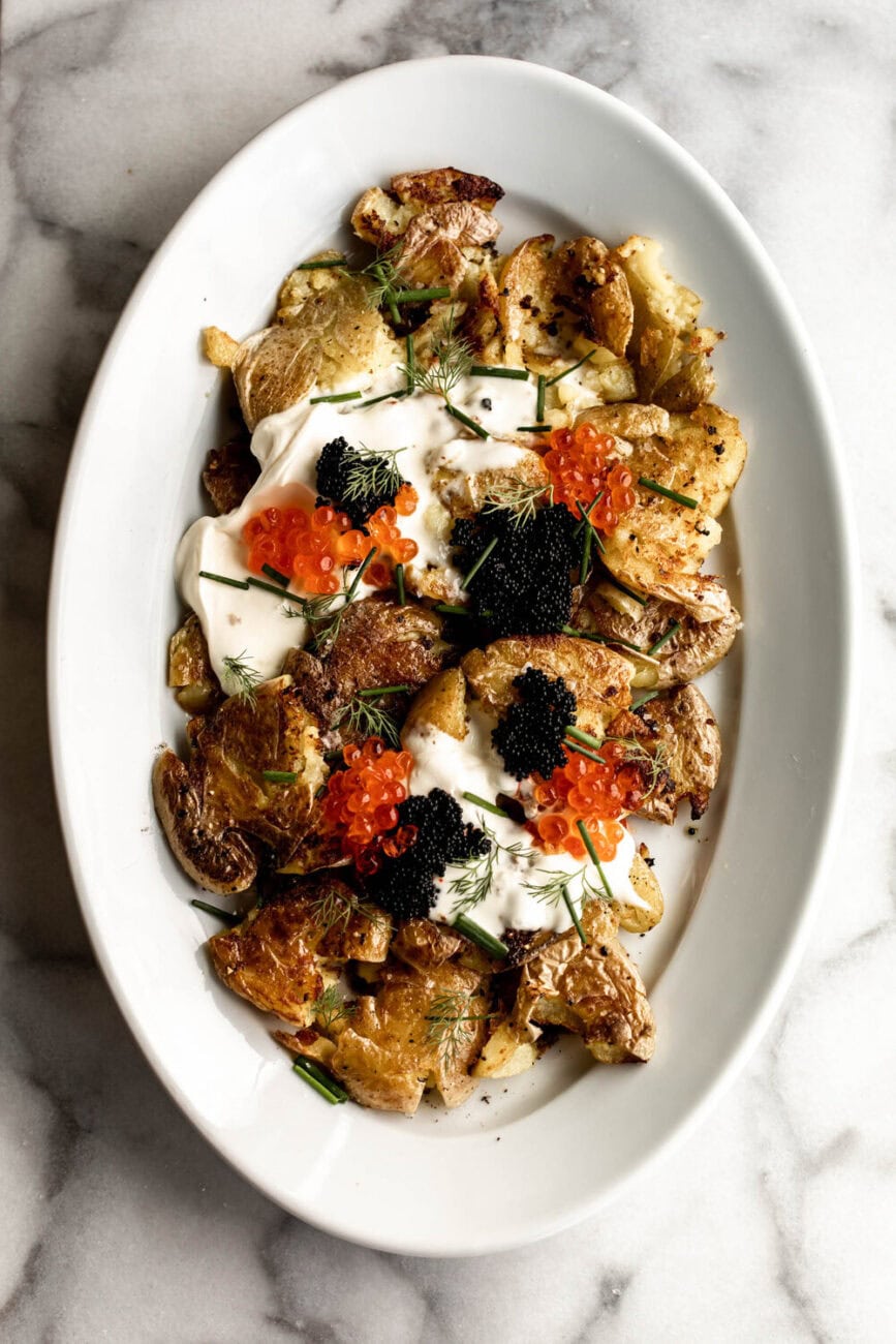 Crispy Smashed Fried Potatoeswith creme fraiche, chives and caviar.